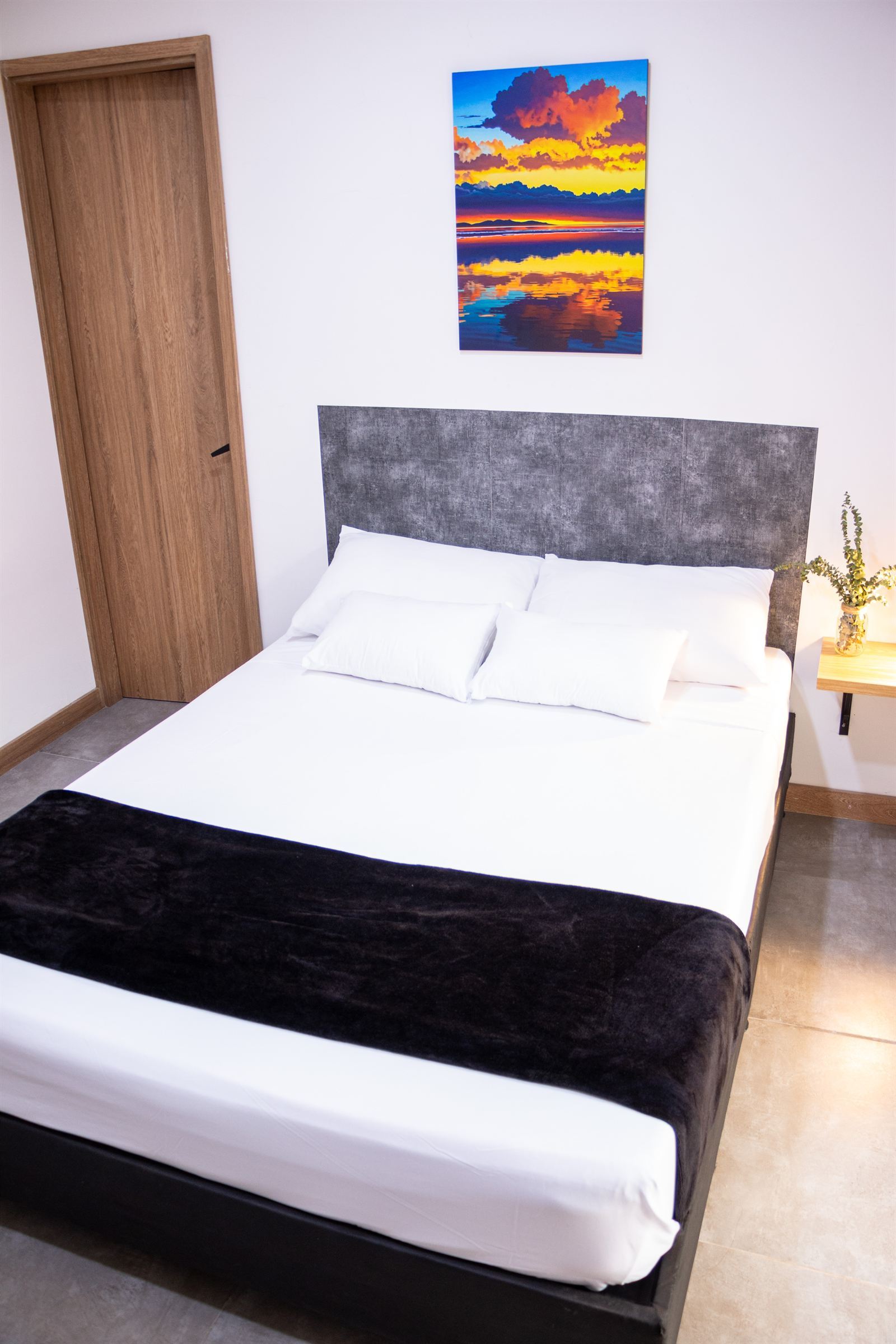 Doppelbett mit schwebendem Nachttisch, brennender Lampe und Pflanze neben dem Kopfteil — Doble Externas Con Balcón