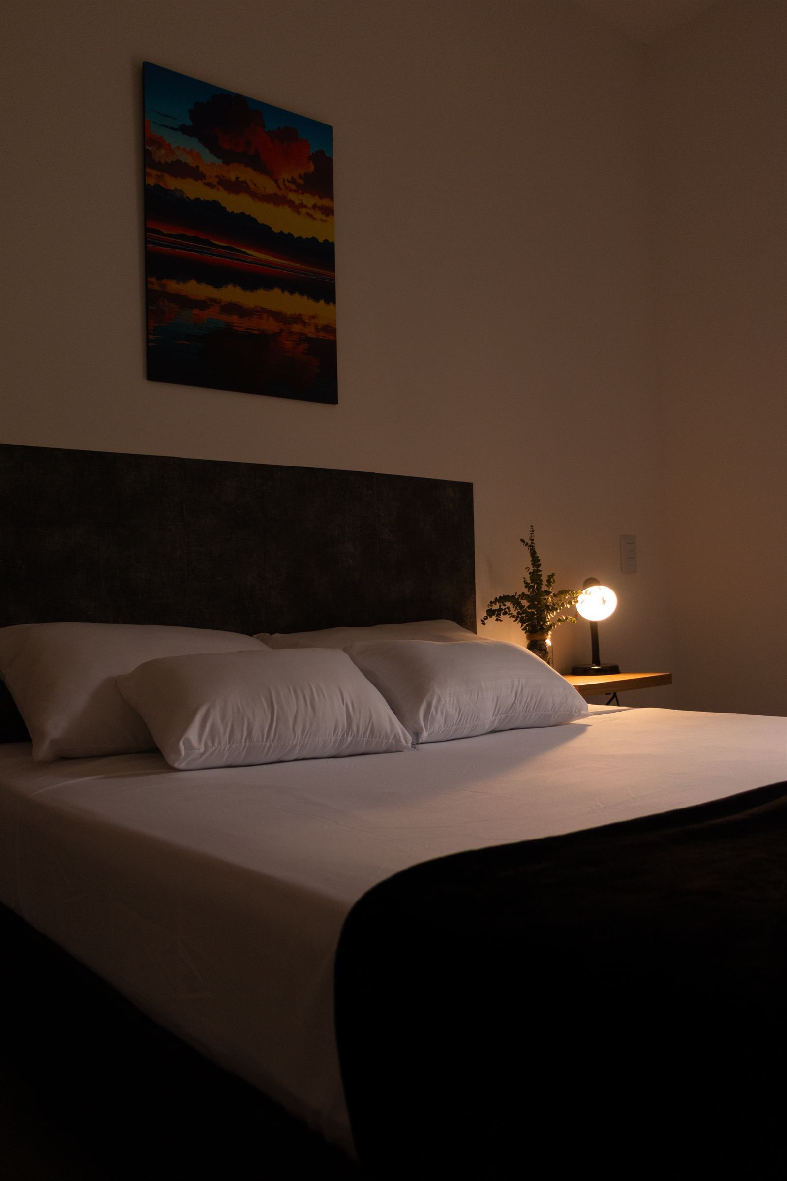 Nächtliche Ansicht des Zimmers mit brennender Nachttischlampe neben dem Bett — Doble Externas Con Balcón